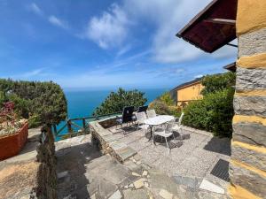 a patio with a table and chairs and the ocean at Il Borgo Di Campi in Riomaggiore