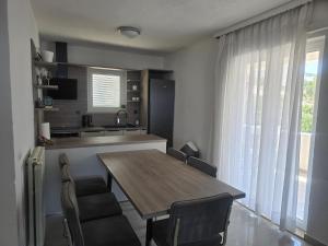 a kitchen and dining room with a wooden table and chairs at Apartments Angela in Primošten