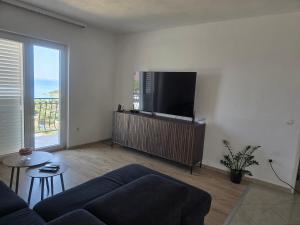 a living room with a couch and a flat screen tv at Apartments Angela in Primošten