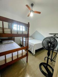 a bedroom with two bunk beds and a fan at Casarão entre Cabo Frio e Búzios Piscina Privativa Ar condicionado, Sinuca, Totó, Churrasqueira 4 quartos Wi-Fi 500mb in Cabo Frio
