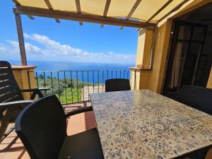 a table and chairs on a balcony with a view of the ocean at Il Borgo Di Campi in Riomaggiore