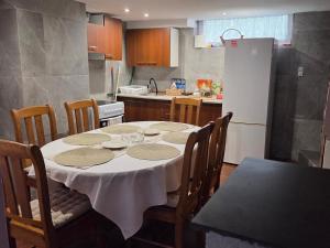a kitchen with a table with chairs and a refrigerator at BECEJŁY de LUX in Becejły