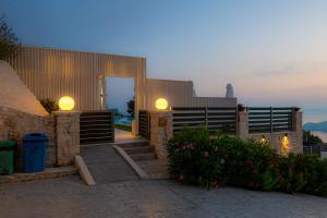 a house with a staircase and a fence with lights at Villa Lamar Private Luxury Villa in Marathias