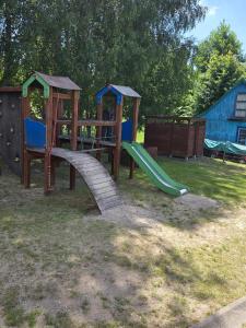 a playground with a slide in the grass at BECEJŁY de LUX in Becejły