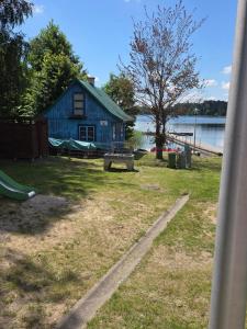 a blue house with a playground next to the water at BECEJŁY de LUX in Becejły