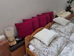a room with two beds with pillows and a wall at BECEJŁY de LUX in Becejły