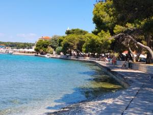 a body of water with people walking on the shore at Marko in Fažana