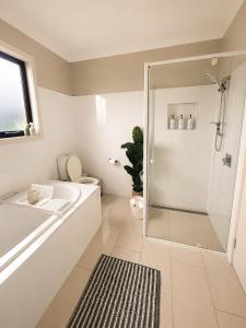 a bathroom with a shower and a toilet and a sink at The Cozy Corner Retreat in Port Sorell