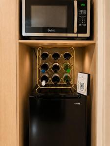 a microwave above a black refrigerator with wine bottles at The Cozy Corner Retreat in Port Sorell