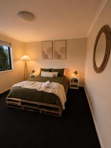 a bedroom with a large bed and a mirror at The Cozy Corner Retreat in Port Sorell