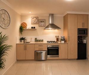a kitchen with wooden cabinets and a stainless steel stove at The Cozy Corner Retreat in Port Sorell +12 photos