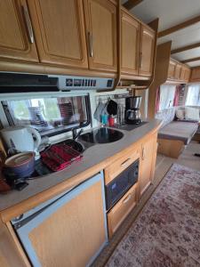 an rv kitchen with wooden cabinets and a sink at Visit Senja Lady in Senja