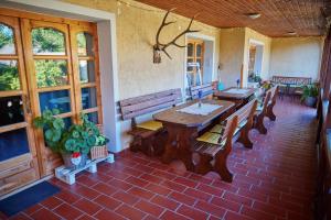 a room with a table and benches on a patio at Borbála Vendégház in Füzér