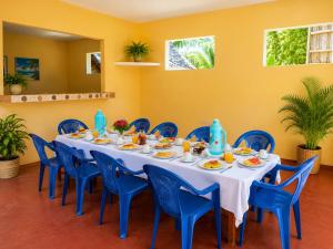 a dining room with a table and blue chairs at Tumaini Bungalows in Nungwi