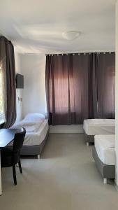 a bedroom with two beds and a desk and a table at Rosenhof am Main in Offenbach +6 photos