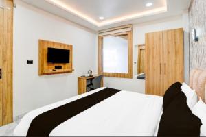a bedroom with a bed and a tv on a wall at Hotel Aarambh By Ramayana Grand-Near Ram Mandir Ayodhya in Ayodhya +32 photos