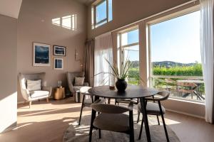 a living room with a table and chairs and a large window at Lindesnes Havhotel in Spangereid