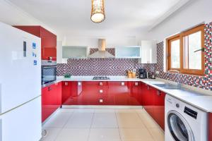 a kitchen with red cabinets and a washer and dryer at The Townhouse Apartment in Kaş