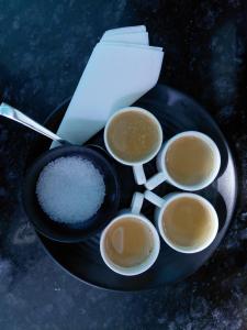 a black plate with rice and a bowl of sugar at The Desire Manali in Manāli