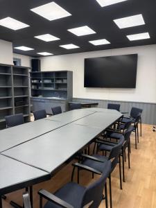 ein großer Konferenzraum mit einem großen Tisch und Stühlen in der Unterkunft Hotel Hammermühle in Stadtroda