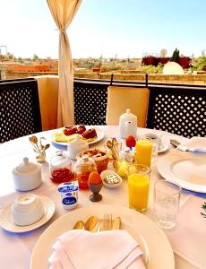 a table with breakfast foods and drinks on it at Riad ABBASSIA Marrakech Première - Authentic Medina Experience in Marrakesh