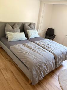 a large bed in a bedroom with a chair at Modern Apartment 2 Graf - New!! in Grafenwöhr