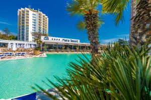 a swimming pool with palm trees and a building at Mera Resort in Venus +104 photos