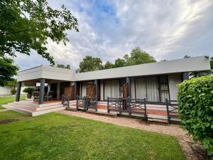 a building with a porch and a grass yard at The Suburban Guest House in Bloemfontein