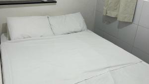a bed with white sheets and pillows in a room at Encantos do Mar Hostel in Recife