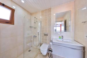 a bathroom with a shower and a toilet and a sink at The Townhouse Apartment in Kaş +25 photos