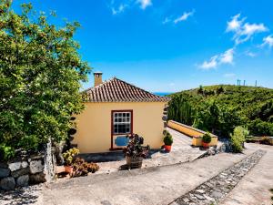 a small yellow house with plants and trees at Emiliana in Puntallana +17 photos