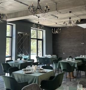 a dining room with tables and chairs and chandeliers at Royal Forest Dilijan in Dilijan