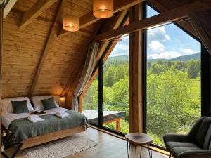 a bedroom in a tree house with a large window at Chata Rosocha domek na wyłączność in Cisna
