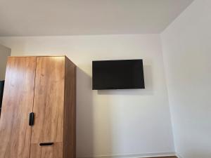 a tv on a wall next to a wooden cabinet at Schönes Apartment in Schwäbisch Hall