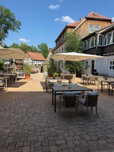 eine Terrasse mit Tischen, Stühlen und Sonnenschirmen in der Unterkunft Hotel Hammermühle in Stadtroda
