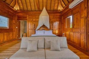 a bedroom with a bed in a room with wooden walls at Padiku Villa Semana Private Pool in Badung +17 photos