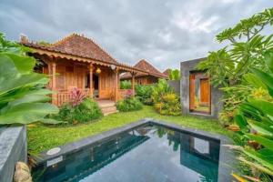 a house with a swimming pool in front of it at Padiku Villa Semana Private Pool in Badung