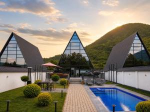 a resort with a pool and mountains in the background at Qafqaz Falcon Chalet in Gabala