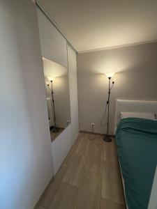 a bedroom with a mirror and a bed and a lamp at Le venizio Sète in Sète