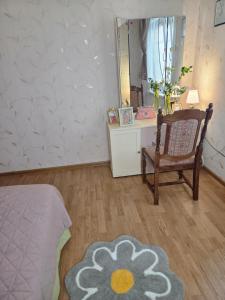 ein Schlafzimmer mit einem Bett, einem Stuhl und einem Spiegel in der Unterkunft Pas tetulę in Anykščiai + 7 Fotos