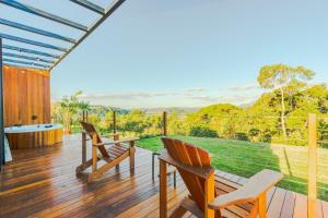 two chairs and a table on a deck with a view at Refúgio Tapera Bungalows & Wellness in Venda Nova do Imigrante