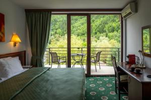 a hotel room with a bed and a balcony at Zan Hotel Voineasa in Voineasa