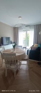 a living room with a table and a couch at Nowoczesny Apartament Tatarska in Przemyśl