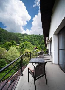 a balcony with a table and chairs on a building at Zan Hotel Voineasa in Voineasa +43 photos