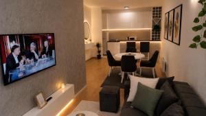 a living room with a couch and a tv on a wall at Urban Center Paraćin in Paraćin