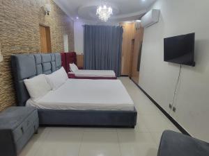 a small room with a bed and a tv at INTOWN Hotel in Islamabad