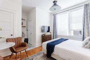 a bedroom with a bed and a table and a chair at Chic Studio Apartment on Oglethorpe Square in Savannah