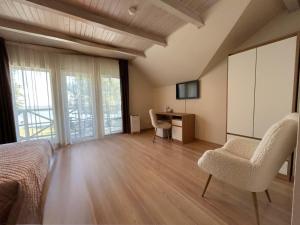 a bedroom with a bed and a desk and chairs at Kurenas in Juodkrantė