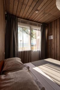 a bedroom with a bed in front of a window at Poilsio namai El Nido in Nida +55 photos