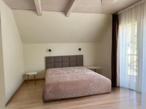 a bedroom with a bed and a large window at Kurenas in Juodkrantė +36 photos
